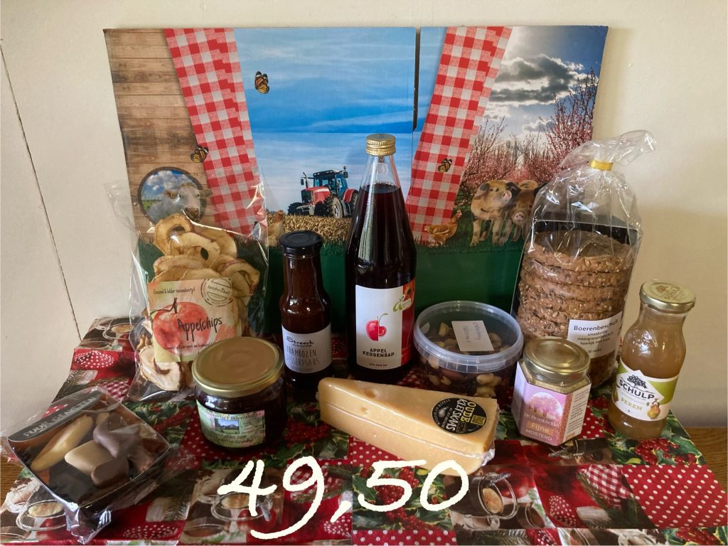 Kerstpakket met de volgende inhoud: Boerenbeschuit, fles puur sap, dessertsaus, zakje appelchips, mooi stuk oude kletskaas, bakje noten, potje Twentse mosterd, grote pot Duvelshofke jam, kerstchocolade, klein flesje puur sap, verpakt in een (kerst) doos